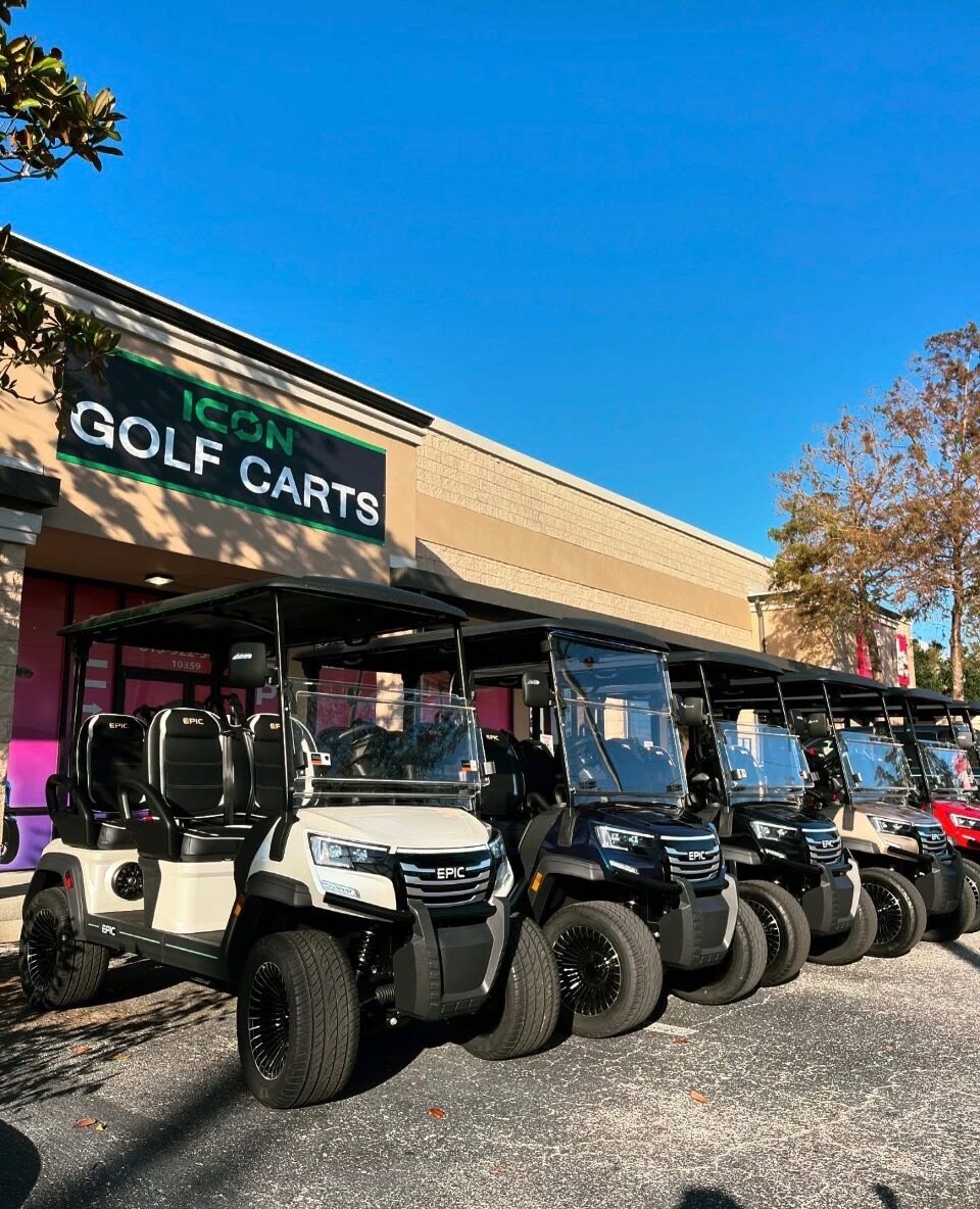 Row of white and black EPIC six-passenger golf carts lined up outside the Icon Golf Carts showroom